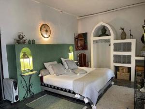 GhazouaVilla Salvatore的一间卧室配有一张带绿色和白色墙壁的床