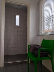 AnnerveenschekanaalDrenths Landgoed, Lekker uit的带淋浴的浴室内的绿色椅子