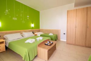 丽都玛里尼Marini Hotel B&B的一间卧室设有两张床和绿色的墙壁
