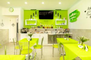 丽都玛里尼Marini Hotel B&B的厨房拥有明亮的绿色墙壁和桌椅
