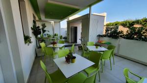 丽都玛里尼Marini Hotel B&B的阳台的天井配有桌子和绿色椅子