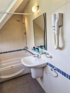 拉兹洛格Villa Deja Vu的浴室配有盥洗盆、镜子和浴缸