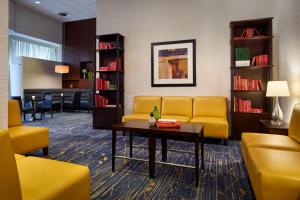 林夕昆高地BWI机场万豪酒店的一间设有黄色沙发和桌子的等候室