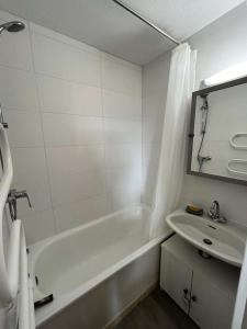 雷阿隆Résidence Relais - 2 Pièces pour 5 Personnes 654的白色的浴室设有浴缸和水槽。