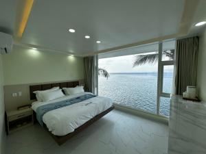 马比尼Luckytito Anilao Resort的一间卧室设有一张床,享有海景
