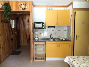 雷阿隆Résidence Aurans - 2 Pièces pour 5 Personnes 734的一间设有黄色橱柜和水槽的小厨房