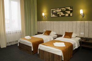 塔拉兹BURSA的酒店客房,配有两张带毛巾的床