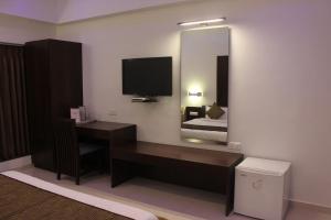 拉杰果德HOTEL THE SENTOSA的酒店客房配有书桌和镜子