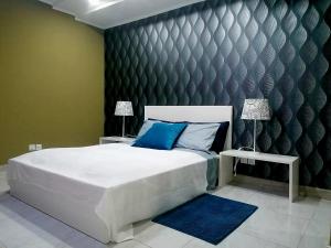 罗安达Lovely Guest House in Luanda的卧室配有带蓝色枕头的大型白色床