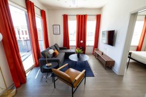 路易斯威尔Modern Nulu 2BR CozySuites 04的客厅配有红色窗帘和沙发
