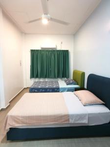新古毛Amuse Homestay at Kuala Kubu Bharu的绿帘间内的两张床