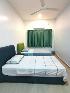 新古毛Amuse Homestay at Kuala Kubu Bharu的绿窗帘间内的两张床