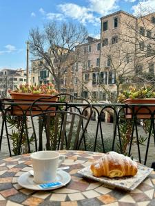 威尼斯洛坎达德尔盖托酒店的一张桌子,上面放着咖啡和羊角面包