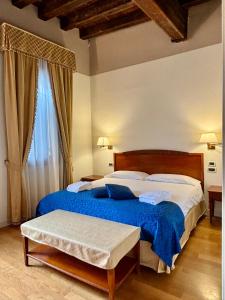 威尼斯洛坎达德尔盖托酒店的一间卧室配有一张带蓝色毯子的大床