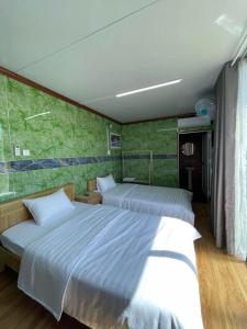 波来古市Motel Ngọc Hiền的一间卧室设有两张床和绿色的墙壁