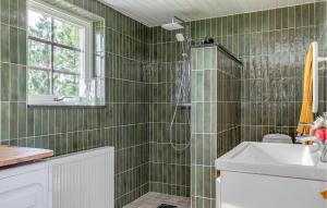 隆德Cozy Home In Lund With Kitchen的绿色瓷砖浴室设有淋浴和水槽