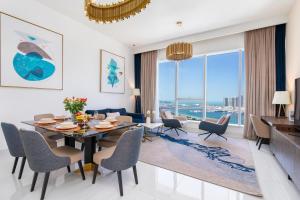 迪拜2BR Avani Palm View - CityApartmentStay的用餐室以及带桌椅的起居室。