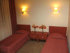 MichałowoZajazd Michałowo的配有两张床和鲜花的旅馆客房
