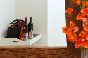 考弗尼西亚Keros Art Hotel的装有瓶装葡萄酒和花瓶的架子