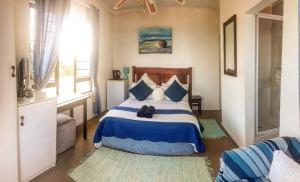 阿曼济姆托蒂Bayview Guest House的卧室配有蓝色和白色的床和窗户。