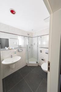 巴伦施泰特Bernstein Schlosshotel Ballenstedt的白色的浴室设有水槽和淋浴。