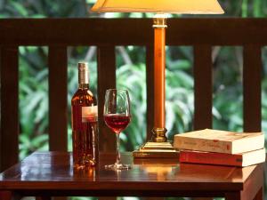 琅勃拉邦3 Nagas Luang Prabang - MGallery Hotel Collection的一瓶葡萄酒和一张桌子上的一杯