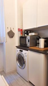 佛罗伦萨Renovated Central Suites的厨房配有洗衣机和微波炉。