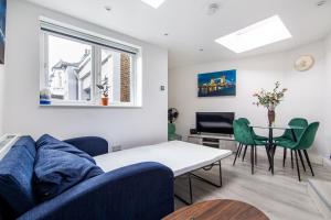 伦敦Cosy 1 Bed apartment with FREE PARKING close to Underground station zone 2 for quick access to Central London up to 5 guests的客厅配有蓝色的沙发和桌子