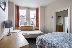 伦敦Cosy 1 Bed apartment with FREE PARKING close to Underground station zone 2 for quick access to Central London up to 5 guests的酒店客房设有两张床和窗户。