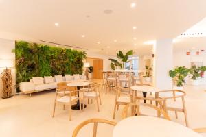 英格兰海滩HL Rondo Hotel的一间带桌椅和绿色墙壁的餐厅