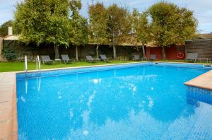 芳特克莱拉Turismo Rural Mas Ametller的一个带椅子和树木的大型蓝色游泳池