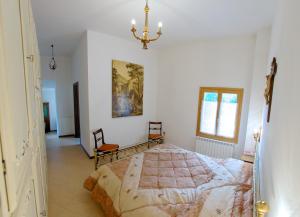 皮亚诺罗Podere Riosto Cantina&Agriturismo的一间卧室配有一张床和一个吊灯