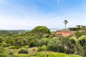 格里莫Les Bastides aux Restanques du Golfe de St Tropez - Maeva Home - Bastide spac 59的山丘上树木的房子