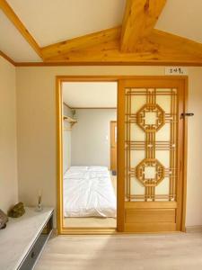 Hanok guesthouse Ann的一间设有门的房间,里面设有一张床