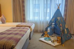 戈尔韦康诺特酒店的一间带两张床的卧室和一个带泰迪熊的帐篷
