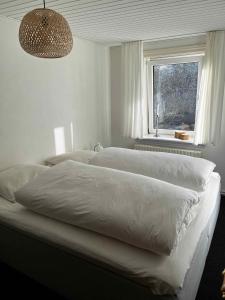 阿灵厄Cozy Holiday Apartment In Allinge的一间卧室设有两张白色的床和窗户