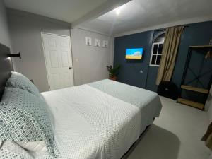 Habitación cerca del aeropuerto #1的卧室配有白色的床和蓝色的墙壁