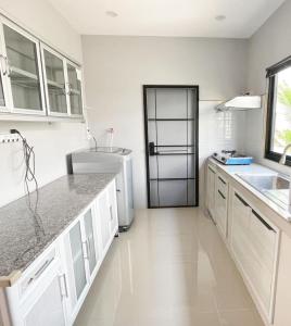 乌隆他尼issara2的厨房配有白色橱柜和冰箱。