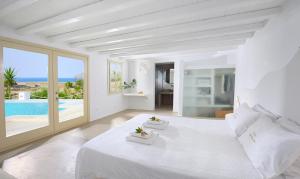 法蒂亚Mykonos Dream Villas的一间白色卧室,配有一张大床和一个游泳池