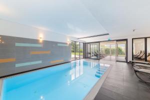 迈埃勒芬Sontheims Naturhotel & Spa的玻璃墙房子内的游泳池