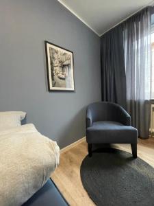 比勒费尔德Zimmer in der Altstadt的卧室配有床边的椅子