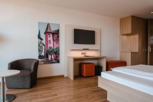 恩根恩格内霍酒店的酒店客房设有一张床和墙上的电视