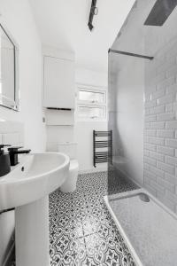伦敦Stylish 2-Bedroom Flat in Walthamstow的白色的浴室设有水槽和卫生间。