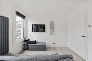 伦敦Stylish 2-Bedroom Flat in Walthamstow的带沙发和电视的白色客厅