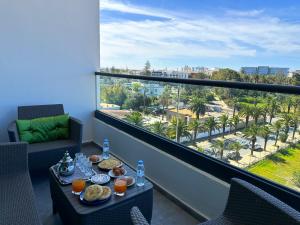 穆罕默迪耶luxe appartement met zeezicht en zwembad Mohammedia Parc的市景阳台配有带食品的桌子