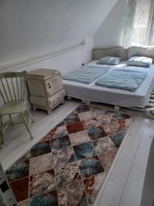 希欧福克Kinga的一间卧室配有一张床、一把椅子和地毯