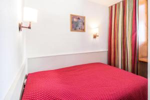 莫尔济讷Résidence Les Fontaines Blanches - maeva Home - Appartement 2 pièces 7 pers 03的一张床上的红色床罩