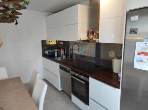 马尔默Privat apartment Bojan的厨房配有白色橱柜和黑色台面