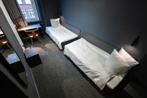 哥本哈根Hotel Maritime的小房间设有一张床和一张带窗户的书桌