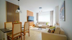 斯克拉斯卡波伦巴Apartamenty Every Sky Szklarska Poręba - Kilińskiego 17A-17B-17C的带沙发的客厅和用餐室